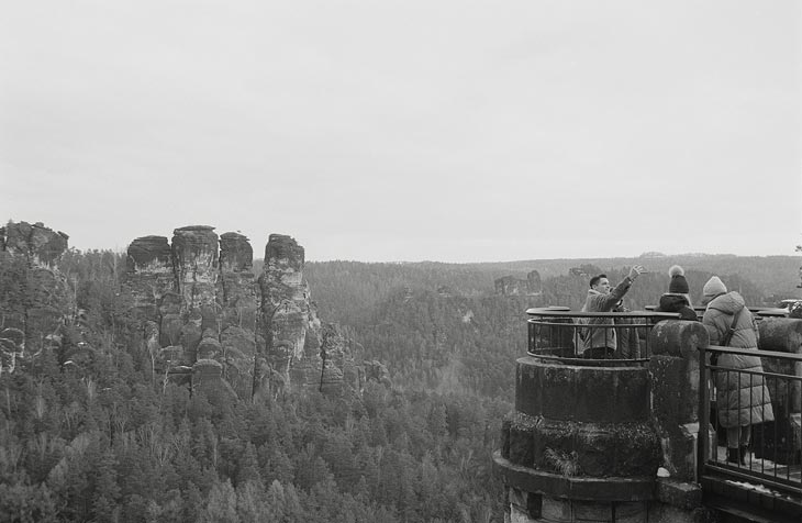 Aufnahme vom Elbsandsteingebirge mit Personen im Vordergrund und Felsen in Luftperspektive