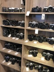 analoge Kameras stehen in einem Regal zum Verkauf